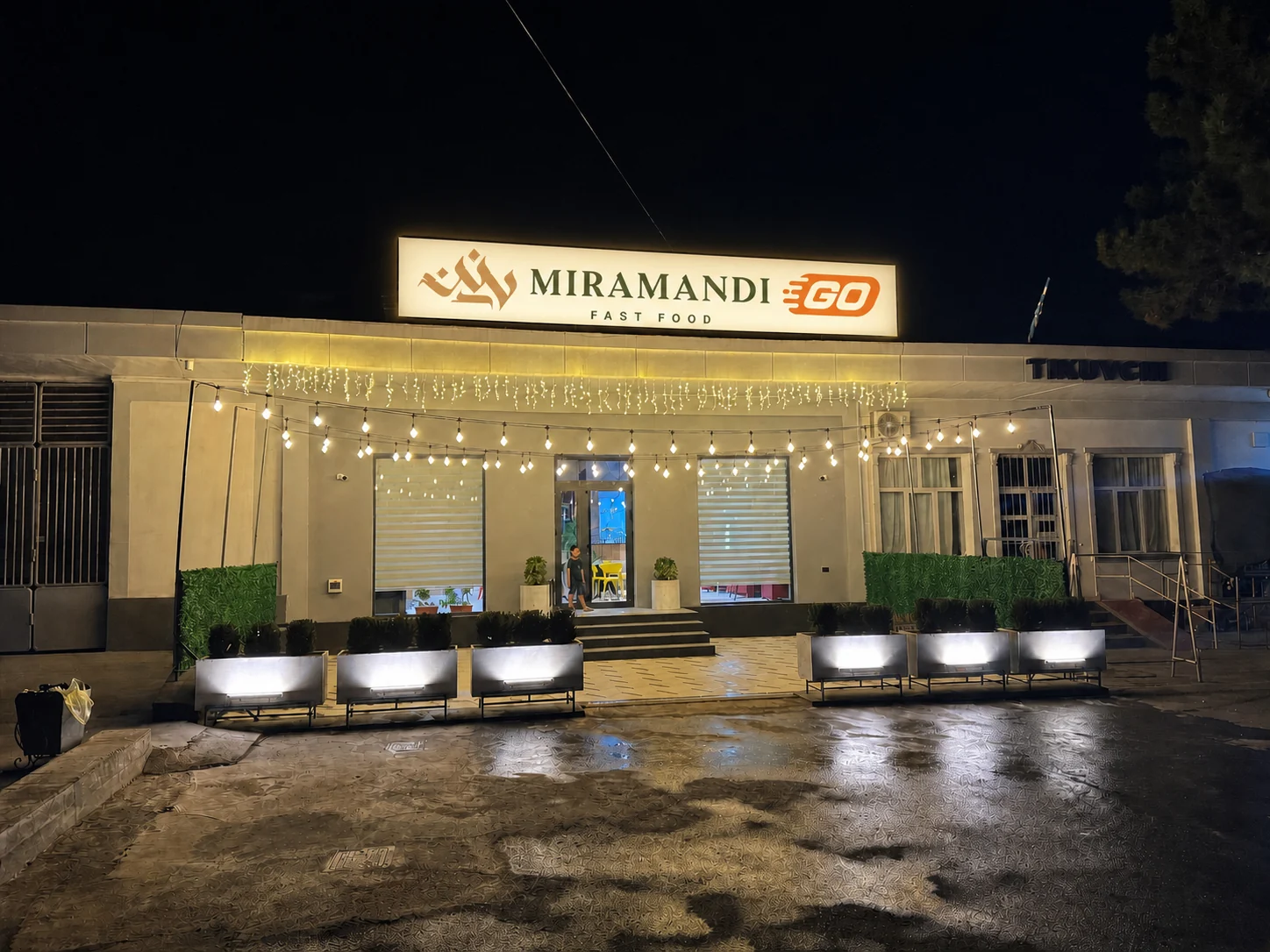 Bino tomidagi yoritilgan Miramandi Go Fast Food peshlavhasi