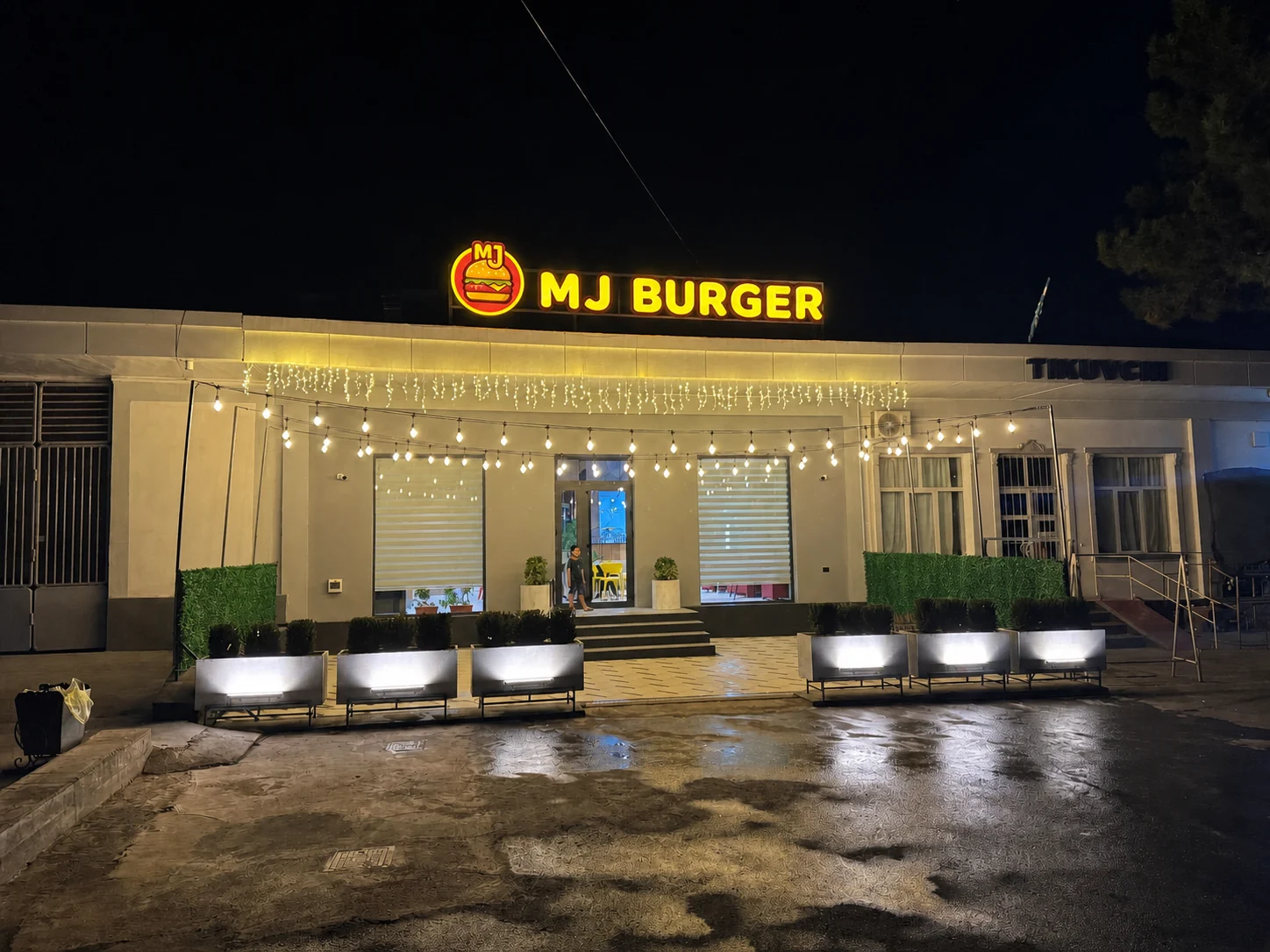 MJ Burger binosi va tom tepasidagi yoritilgan peshlavha