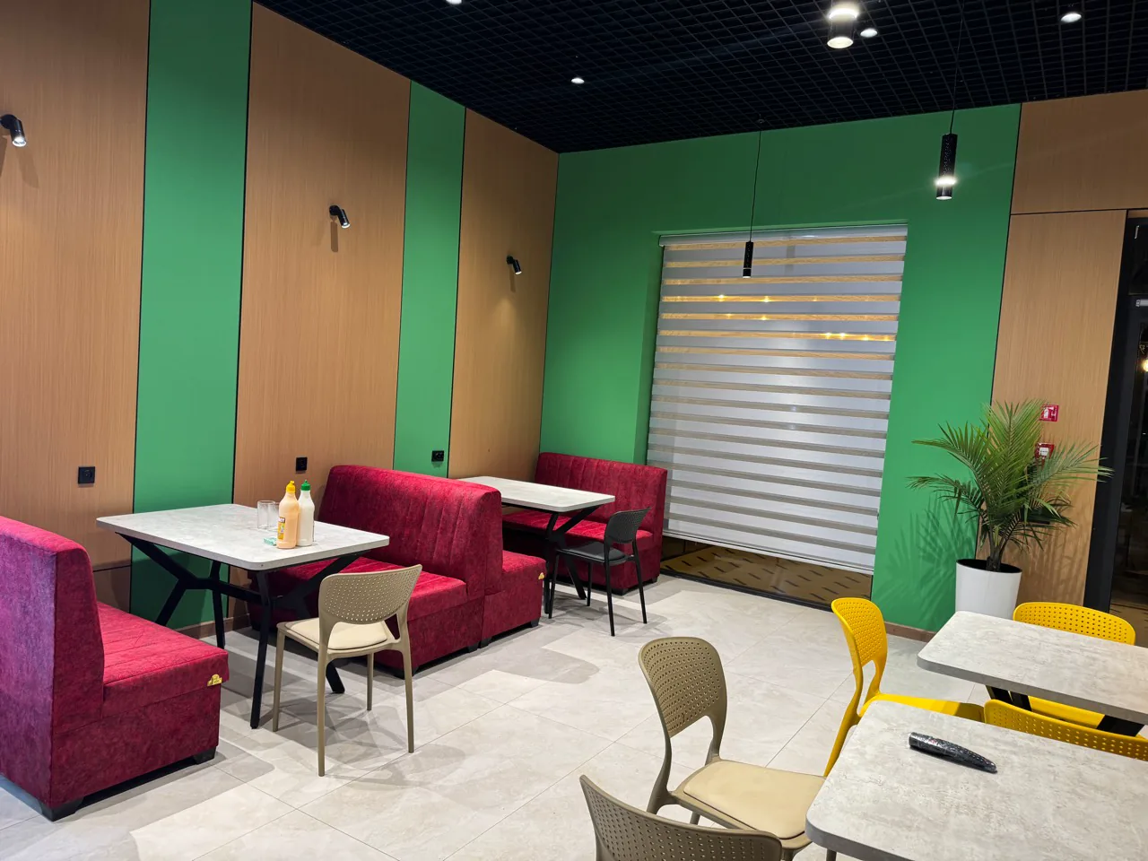 MJ Burger interyeri — yashil devorlar, yog'och panellar va bordo o'rindiqlar
